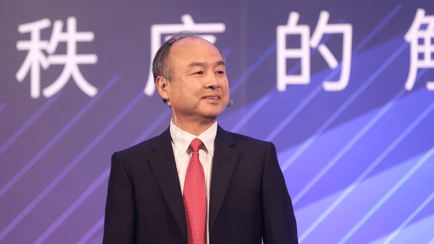 Masayoshi Son, SoftBank founder and CEO, in a dark suit and red tie, smiling on stage in front of a purple screen with Chinese characters, Taipei, June 2019